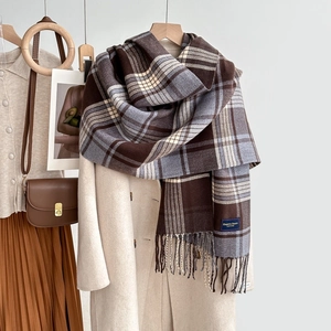 Écharpe classique à carreaux avec franges en café et beige suspendue sur un manteau