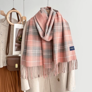 Écharpe à carreaux rose et gris en imitation cachemire avec franges sur un manteau