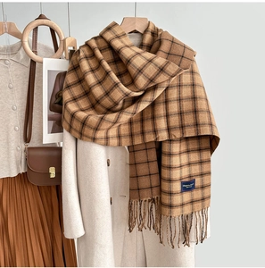 Detail of soft cashmere-like plaid scarf tassels on a classic autumn wool coat outfit