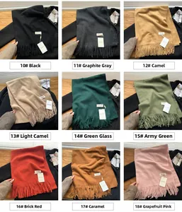 Detail view of colorful soft knitted scarves with long tassels in a variety of solid colors