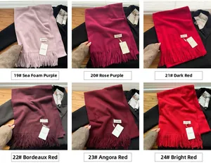 Close-up of soft solid fringe scarves in purple and red shades with tassel details