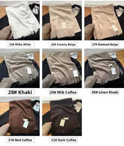 Detailed close-up of soft knit scarves in various earth tones with fringe edges