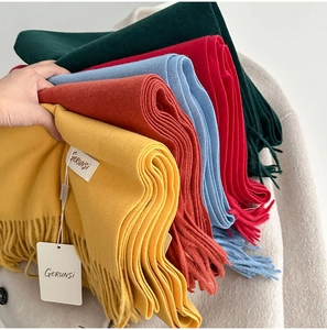 Close-up of soft solid color scarves with decorative fringes in multiple vibrant colors
