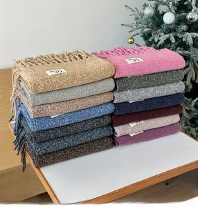 Macro shot of colorful fringed wool scarves with logo labels in warm holiday setting