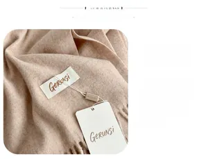 Close-up of light beige baby velvet scarf showing soft knit texture and fringe detail