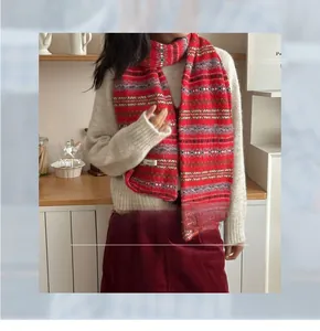 Detail of Fair Isle wool blend scarf with red and grey patterns and brand label