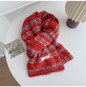 Detail of Fair Isle knit scarf with red and white patterns and brand woven label