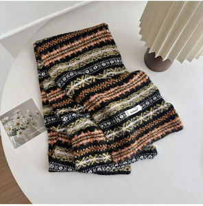 Close-up of Fair Isle knit scarf featuring vintage geometric patterns and brand tag