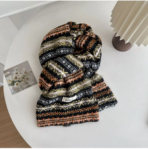 Close-up of Fair Isle knit scarf texture with geometric patterns and brand label detail
