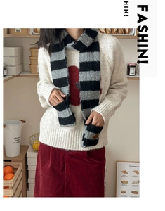 Detail of grey striped knit scarf featuring functional hand-warming pockets