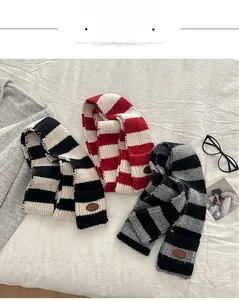 Detail view of the striped wool blend scarves with vintage brown leather patch