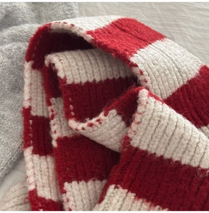 Close-up of thick knit wool blend scarf with red and white bold stripe texture