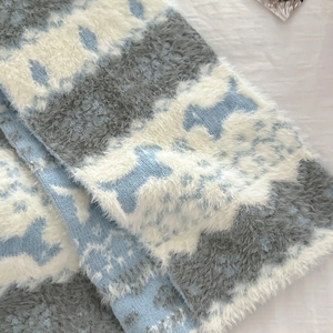 Detail of soft Fair Isle knit scarf with cute blue and white puppy jacquard pattern