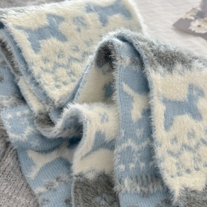 Detail of soft Fair Isle knit scarf with cute puppy patterns and plush faux mink texture