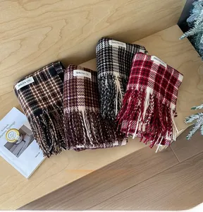 Close-up of assorted plaid scarves with fringe details on a warm wooden background
