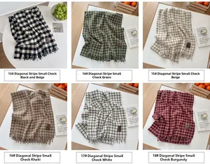 Detail view of plaid scarves in multiple colors with tassels and knit texture