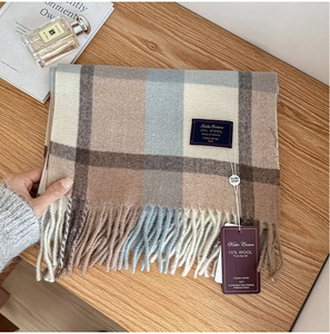Detail of wool plaid scarf showing fabric texture, fringe, and classic brand label