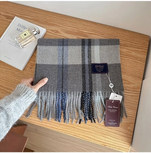 Close-up of wool blend plaid scarf with long tassels and detailed woven texture