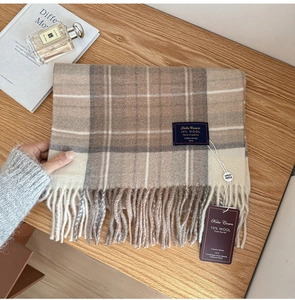 Close-up of classic plaid wool scarf with herringbone fringe and brand labels