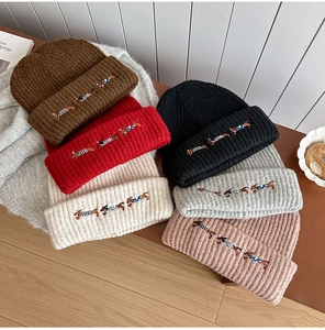 Detailed view of colorful knit beanies featuring exquisite dachshund dog embroidery