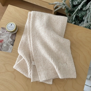 Close-up of cream wool blend knit scarf featuring delicate bow embroidery and rib texture