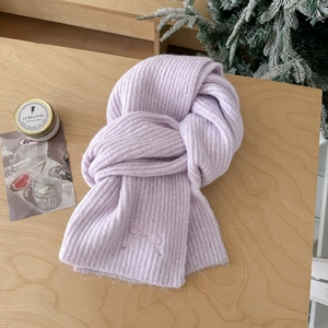 Soft lavender wool blend knit scarf with bow embroidery on light wood background