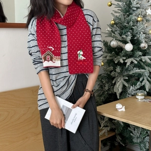 Detail of red knitted scarf with white polka dots and cute dog embroidery for Christmas
