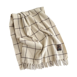 Plaid cashmere-feel scarf with fringe edges and vintage label on white background
