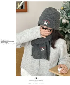 Close-up of knit hat and scarf set featuring dog embroidery in a cozy winter setting