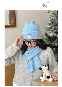 Close-up of light blue knitted hat and scarf set with cute cartoon puppy embroidery