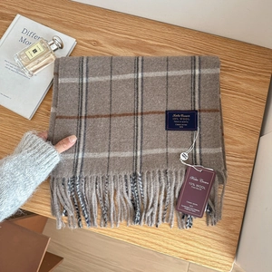 Classic British style wool blend plaid scarf with fringe and brand label on wood background