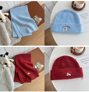 Close-up of ribbed knit hat and scarf set with cute cartoon dog embroidery detail