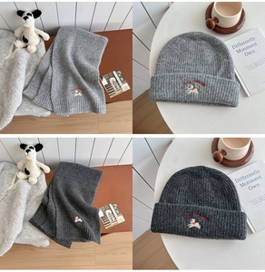 Detailed view of grey knitted scarf and hat set with embroidered puppy design