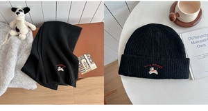 Close-up of black knitted scarf and beanie set with cute puppy embroidery detail