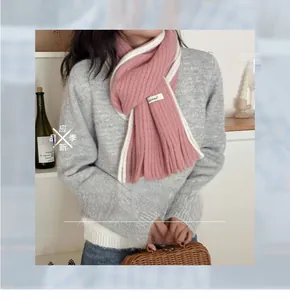 Détail d'une écharpe en mohair rose et blanc avec maille épaisse et franges