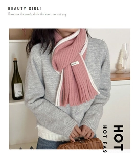 Gros plan sur l'écharpe en mohair rose et crème avec des franges et une étiquette tissée