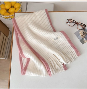 Détail d'une écharpe en maille mohair douce avec bord rose et franges sur le bureau