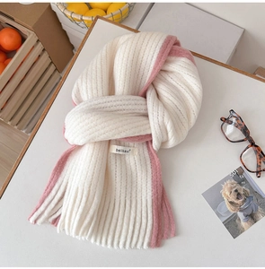 Gros plan sur la maille et les franges d'une écharpe d'hiver bicolore en mohair