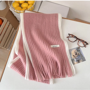 Détail d'une écharpe en mohair rose et blanc avec texture côtelée et franges