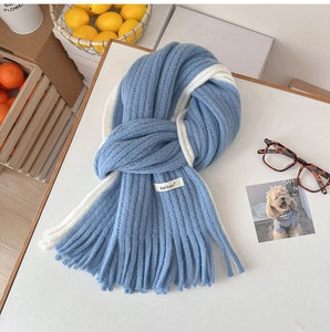 Détail de l'écharpe en mohair bleu et blanc avec franges douces et étiquette tissée