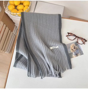 Détail d'une écharpe en mohair gris avec texture côtelée et franges douces