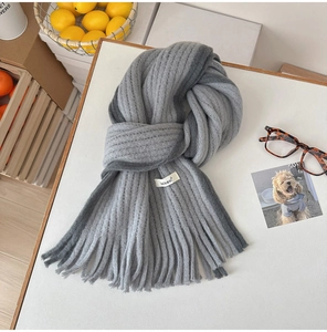 Détail d'une écharpe en mohair gris dégradé avec texture côtelée et longues franges
