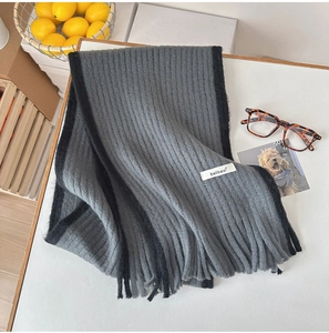 Détail d'une écharpe en mohair gris et noir avec maille côtelée et franges souples