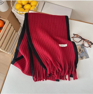 Vue détaillée de l'écharpe en mohair tricoté rouge et noir avec texture côtelée et franges