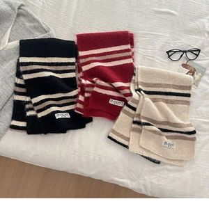 Detailed close-up of soft wool-blend striped knitted scarves with woven brand labels