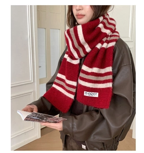 Detail of red and white striped knit scarf with wool texture and woven brand label
