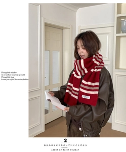 Close-up of red and white striped knit scarf with brand label and wool texture
