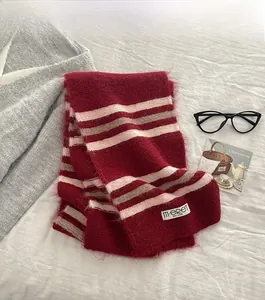 Detail of red and cream striped mohair knit scarf with fluffy texture and brand label