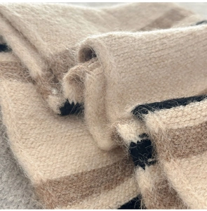 Macro detail of wool blend knit scarf showing thick striped texture and fuzzy fibers