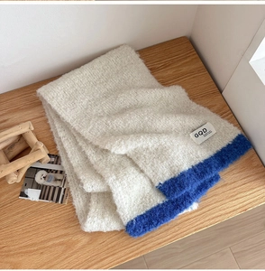 Detailed texture of thick color-block knit scarf in off-white and electric blue